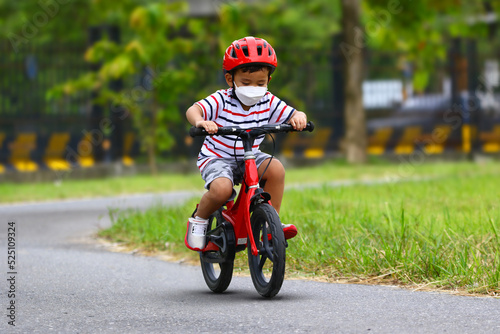 Asian Little boy riding a red bicycle