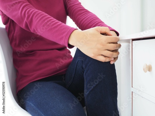 Young woman suffering from knee pain at home. Closeup photo, blurred. photo