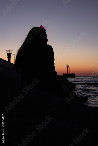 Dziewczyna siedząca na skałach na morzem