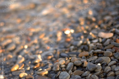 A transparent sea wave rolls over a rocky beach  the concept of rest and travel  calmness and reflection on a warm summer day  defocusing  blurred background  selective focus  bokeh.