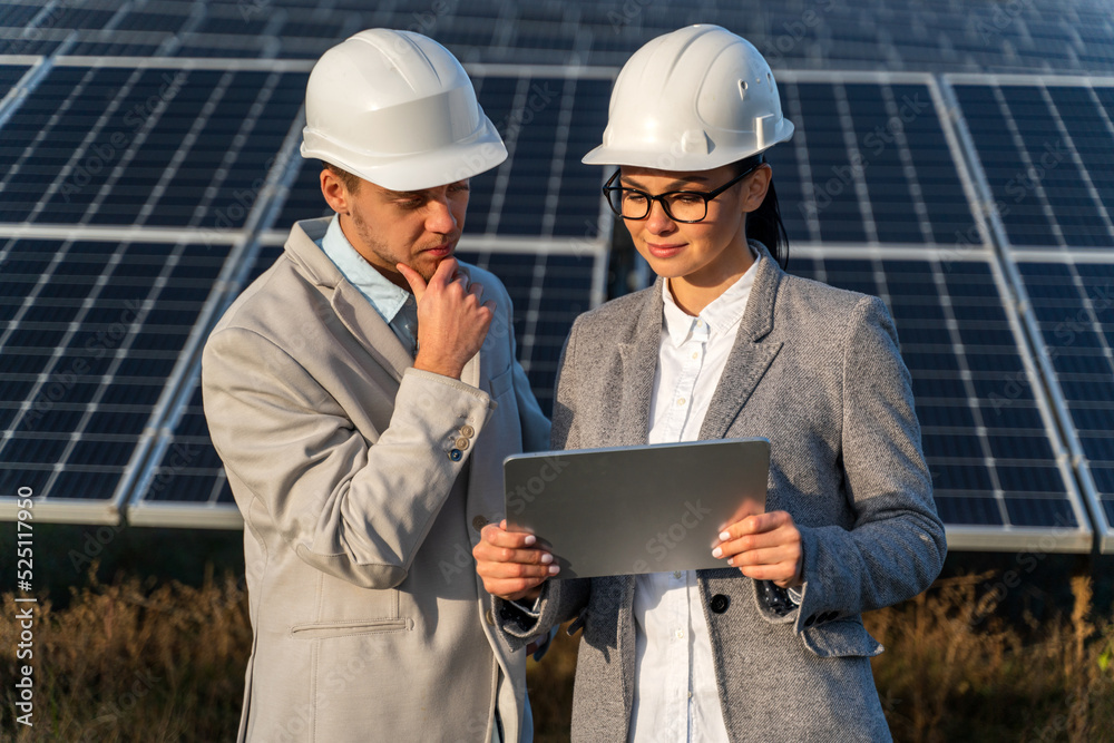 Professional woman and man engineers is looking to the efficient plan on the tablet in the meadow Professional woman and man engineers is looking to the efficient plan on the tablet in the meadow