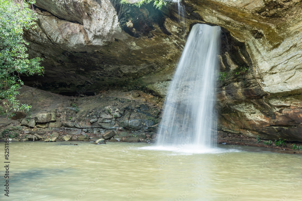 Naklejka premium Saeng Chan waterfall in the deep humid forest at Ubon Ratchathani, Thailand, Leaf moving low-speed shutter blur.