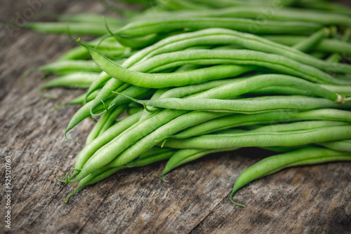 Organically homegrown French filet green beans, 'Maxibel' variety, in a quart container on a rustic vintage wooden background