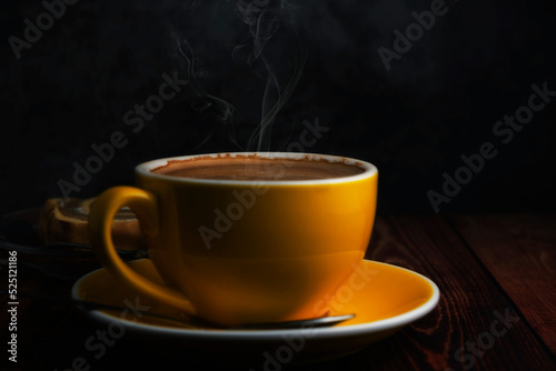 hot latte in yellow glass on wooden table