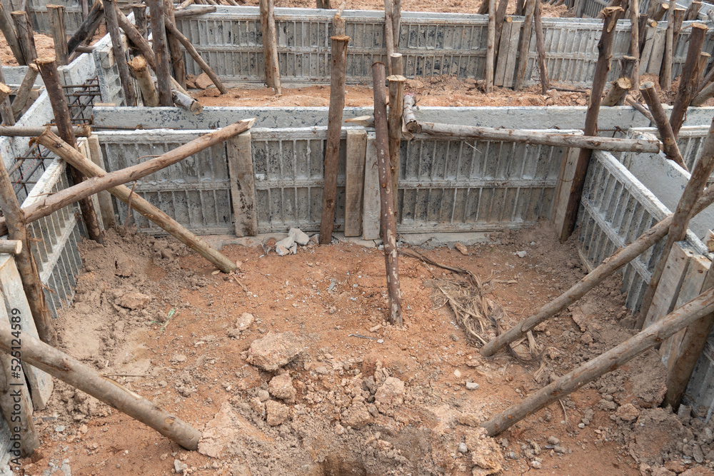 Block formwork for house beams with supported by wooden logs. Construction of the foundation of the house on the ground during the day time. Block formwork for house beams with supported by wooden logs. Construction of the foundation of the house on the ground during the day time.