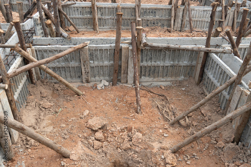 Block formwork for house beams with supported by wooden logs. Construction of the foundation of the house on the ground during the day time.