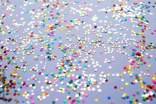 multicolor sparkles on a purple background. Festive backdrop for your projects.