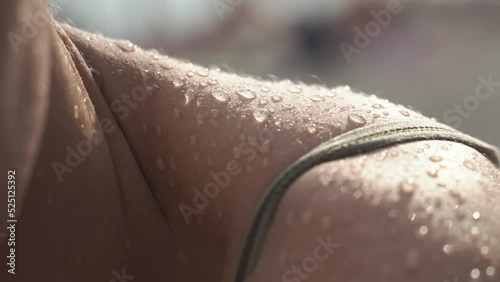 a close-up of the drops of water on the girl's skin after taking the shower flow down. Large drops of water on the body of a girl after the sea.