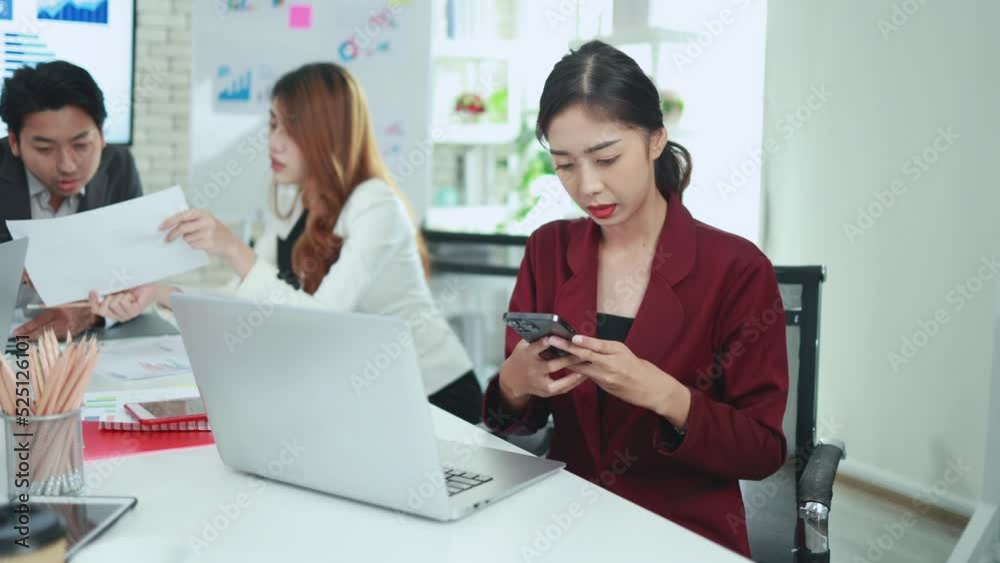 Asian business people talking on the phone and working together in the office Asian business people talking on the phone and working together in the office