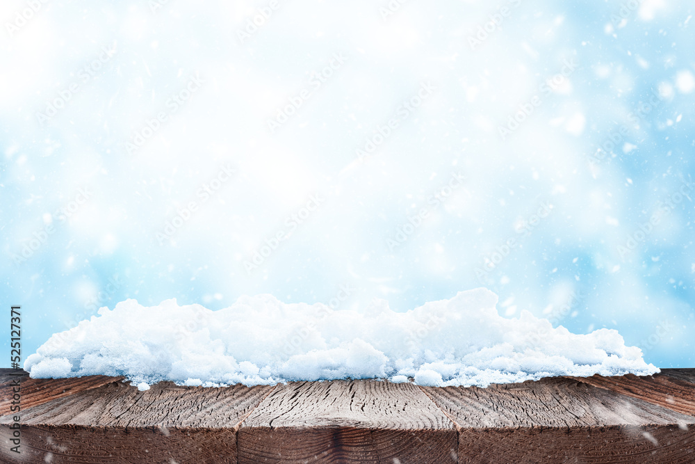 Winter or christmas background. Empty wood table over blue bokeh background with snow. Template for product display
