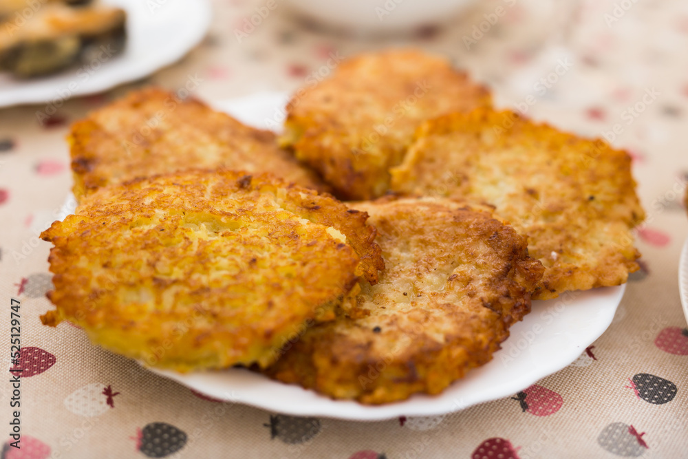Fried grated potato pancakes with sour cream on white plate