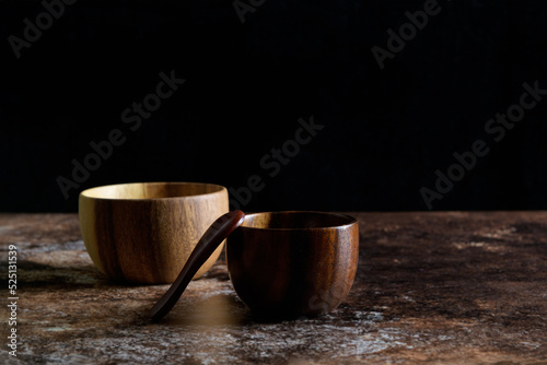 Two japanese style wooden bowl with wooden spoon on dark grunge brown background with copy space, still life minimalist composition