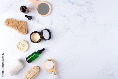 Opened moisturizer cream jar and essential or lotion in amber glass bottle and set of skin and bodycare products on white background. Cosmetic packaging mockup. Natural cosmetics home skincare routine © Anna Fedorova