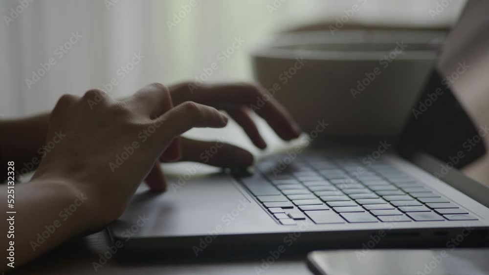 Handheld pivoting around close up of a woman hand browsing swipe and scroll on a laptop touchpad