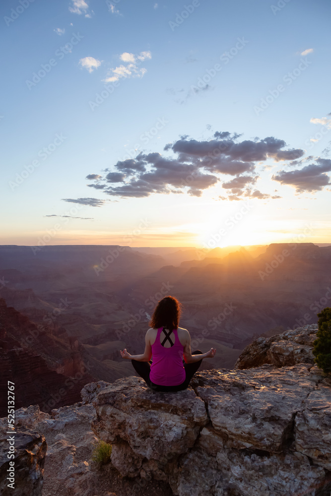 Obraz premium Adventurous Traveler woman doing meditation on Desert Rocky Mountain American Landscape. Cloudy Sunny Sky. Grand Canyon National Park, Arizona, United States. Adventure Travel