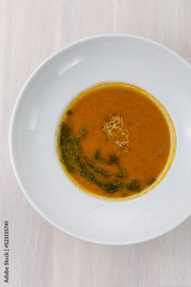 carrot soup with microgreens and green oil on the table top view carrot soup with microgreens and green oil on the table top view