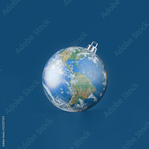 Christmas tree ornament ball made of planet Earth against isolated dark blue background. Minimal creative concept of New Year's Eve or touristic agency greeting card. The world provided by NASA.