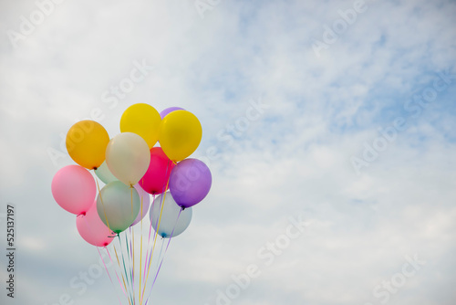 Balloon in Happy birthday party sky background with string and ribbon (yellow,pink,blue,violet,purple) helium Ballon floating in celebrate wedding day.Concept of balloon in wedding and birthday party.