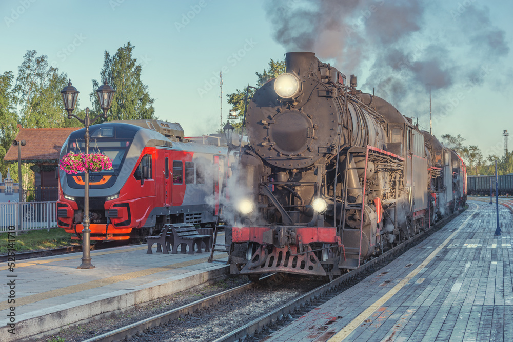 Steam locomotives stand by the wooden platform.