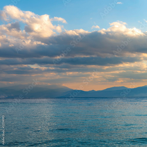 Cloudy sky above the sea and mountains in the background of the horizon. The change of weather is continuous in all seasons. © Dimitrios