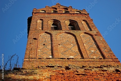 ruined old catholic church made of red brick against the blue sky