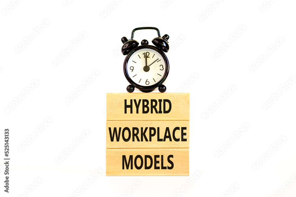Hybrid workplace models symbol. Concept words Hybrid workplace models on wooden blocks. Black alarm clock. Beautiful white table white background. Business hybrid workplace models concept. Copy space Hybrid workplace models symbol. Concept words Hybrid workplace models on wooden blocks. Black alarm clock. Beautiful white table white background. Business hybrid workplace models concept. Copy space