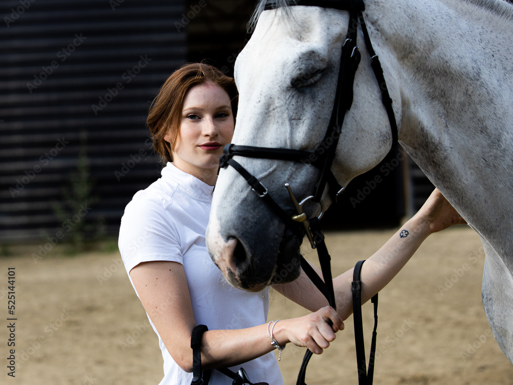 Obraz premium Portrait of a girl preparing her horse for riding.