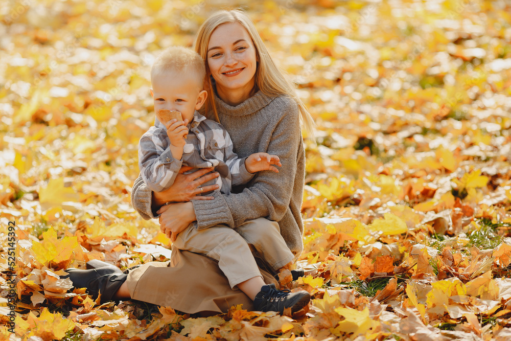 Mother with little son sitting in a autumn field Mother with little son sitting in a autumn field