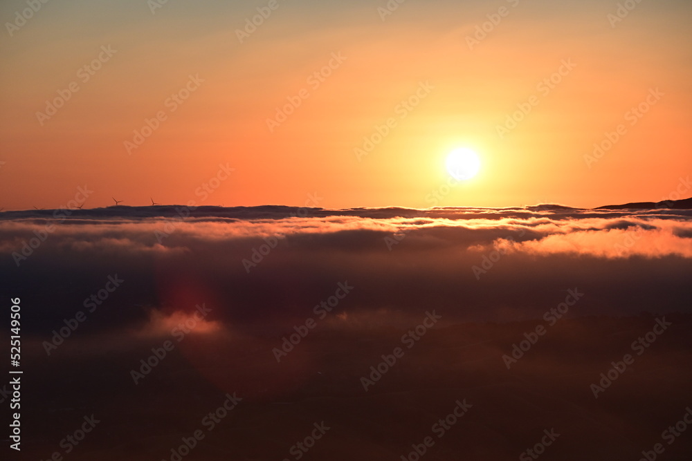 sunrise over clouds and town