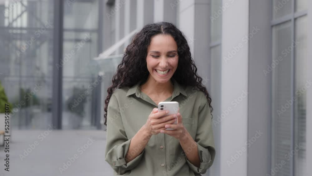Adult woman 30s businesswoman entrepreneur female winning with good result news in cell phone standing outdoors success win opportunity internet bet achievement mobile app surprised lady celebrating Adult woman 30s businesswoman entrepreneur female winning with good result news in cell phone standing outdoors success win opportunity internet bet achievement mobile app surprised lady celebrating