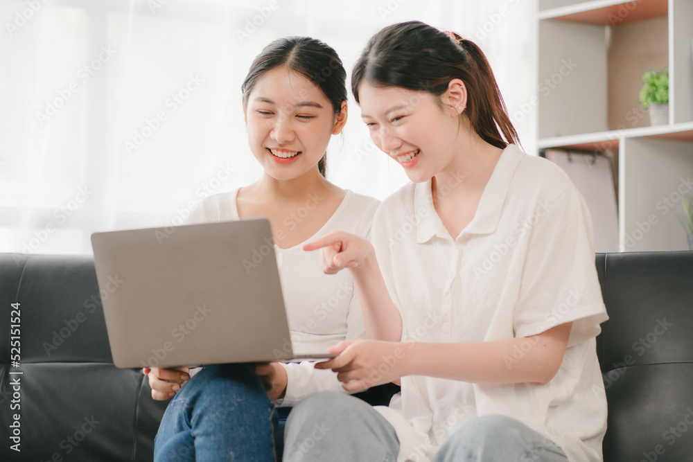 Asian woman happy holding laptop phone sitting sofa smiling good mood indoors indoors Asian woman happy holding laptop phone sitting sofa smiling good mood indoors indoors