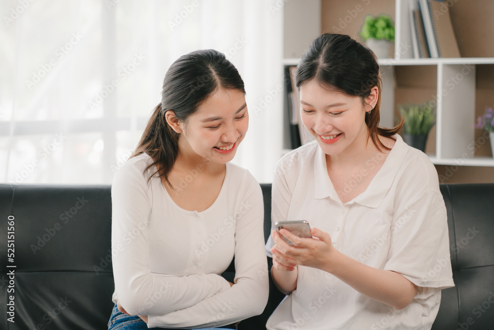 Asian woman happy holding laptop phone sitting sofa smiling good mood indoors indoors Asian woman happy holding laptop phone sitting sofa smiling good mood indoors indoors