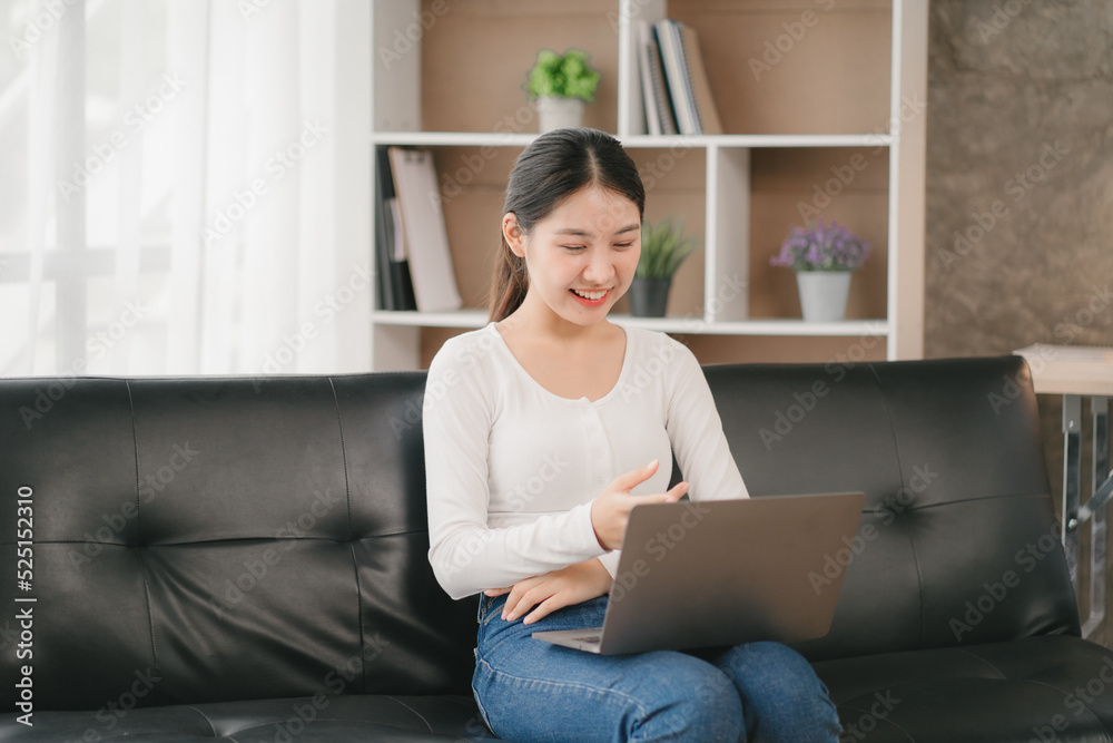 Asian woman happy holding laptop phone sitting sofa smiling good mood indoors indoors Asian woman happy holding laptop phone sitting sofa smiling good mood indoors indoors