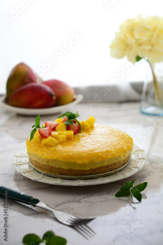 mango cheese cake a white plate , Marple background , white background .