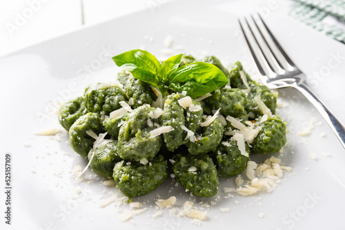 Piatto di deliziosi gnocchi di spinaci conditi con burro e formaggio, cibo italiano 