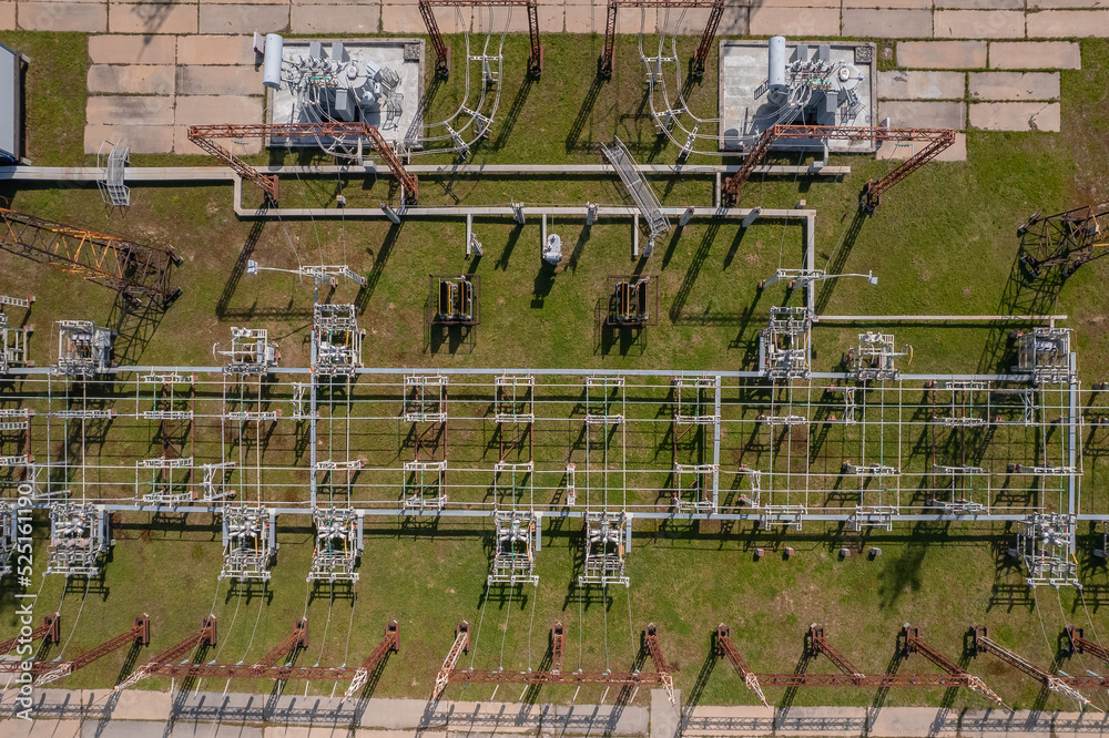 Industry photo drone top view, electric transformer transmission towers with high voltage wires next to gas turbine power plant