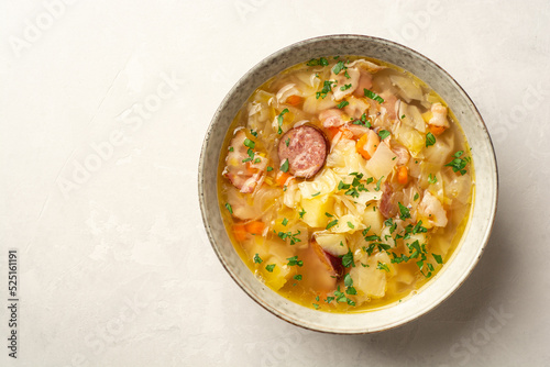 Polish sauerkraut soup Kapusniak in bowl on concrete background