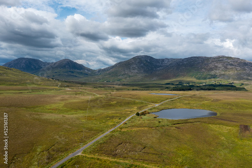 country road leads into the wild landscape of the Connemara National Park in western Ireland