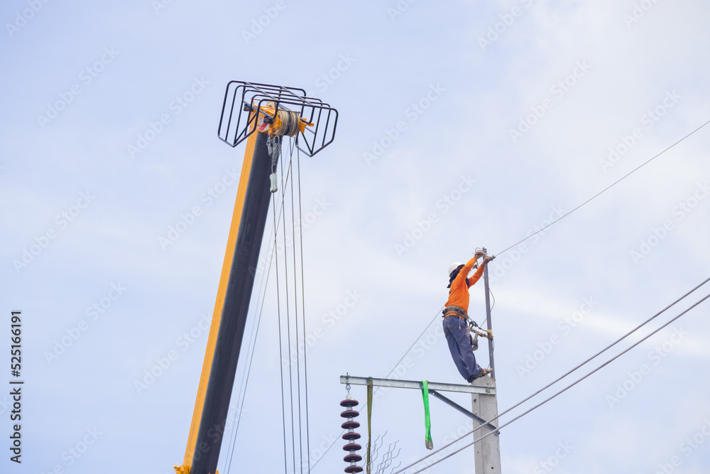 An electrician climbs a cable car and a light pole with safety devices to install a new electrical system.