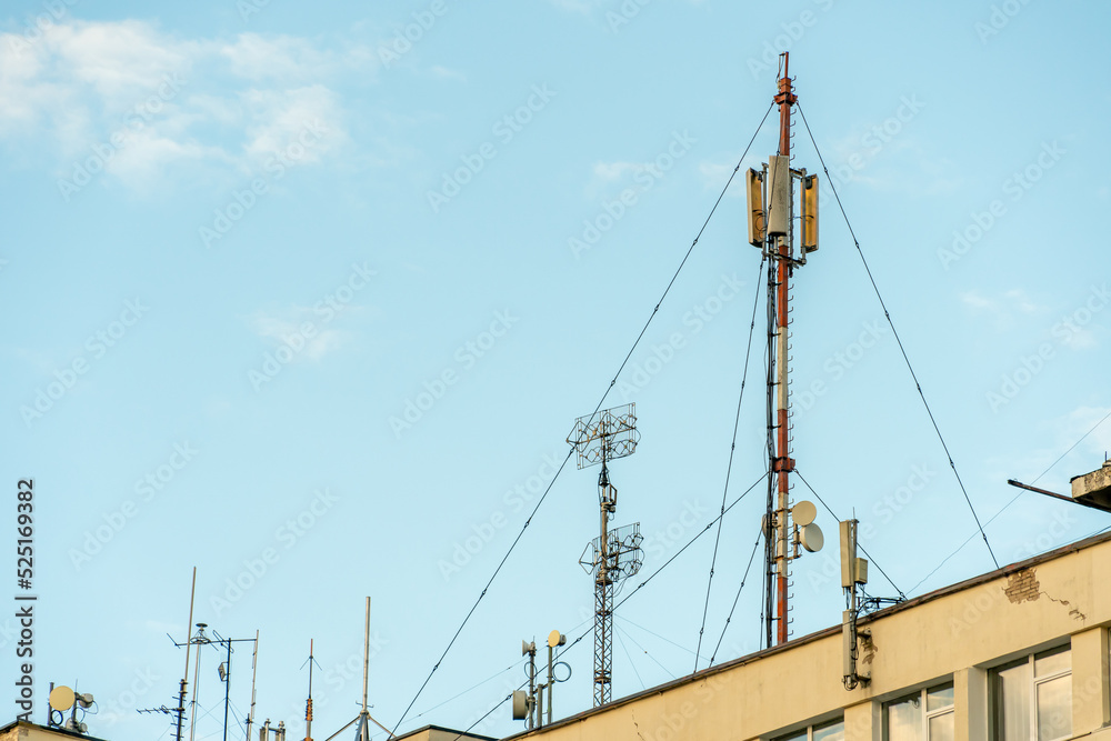 New GSM antennas on a high tower against a blue sky for transmitting a 5g signal are dangerous to health. Radiation pollution of the environment through cell towers. The threat of extinction