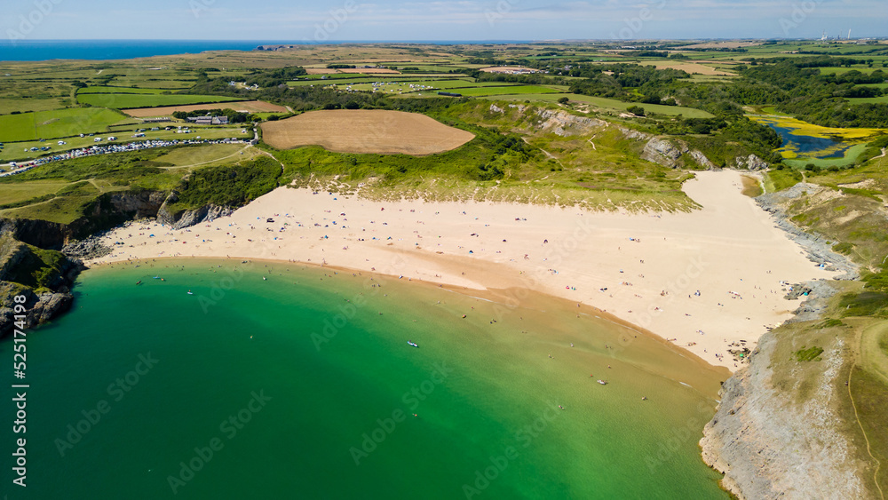 Aerial view of a large, busy sandy beach and rocky coastline in West Wales (Broad Haven South, Wales)