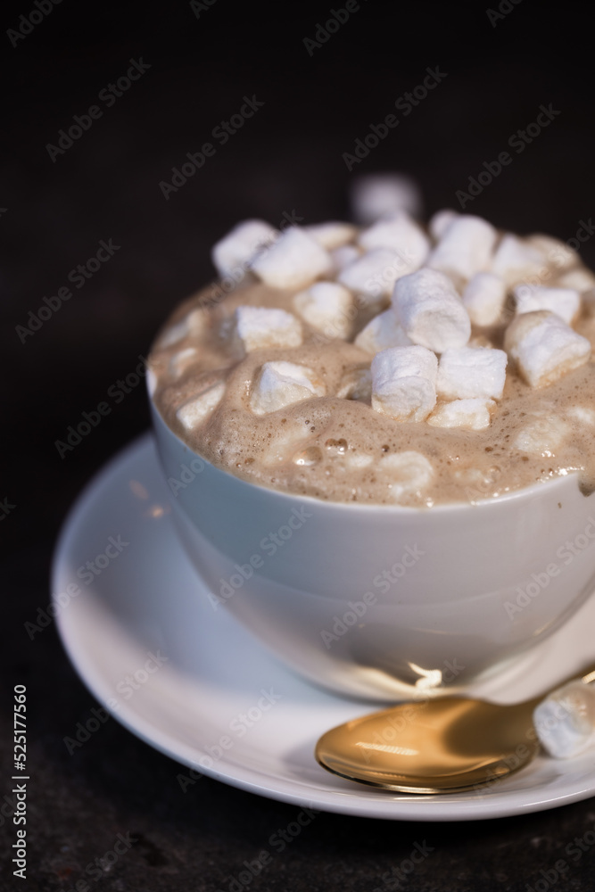 a white cup of coffee with marshmallows on the table