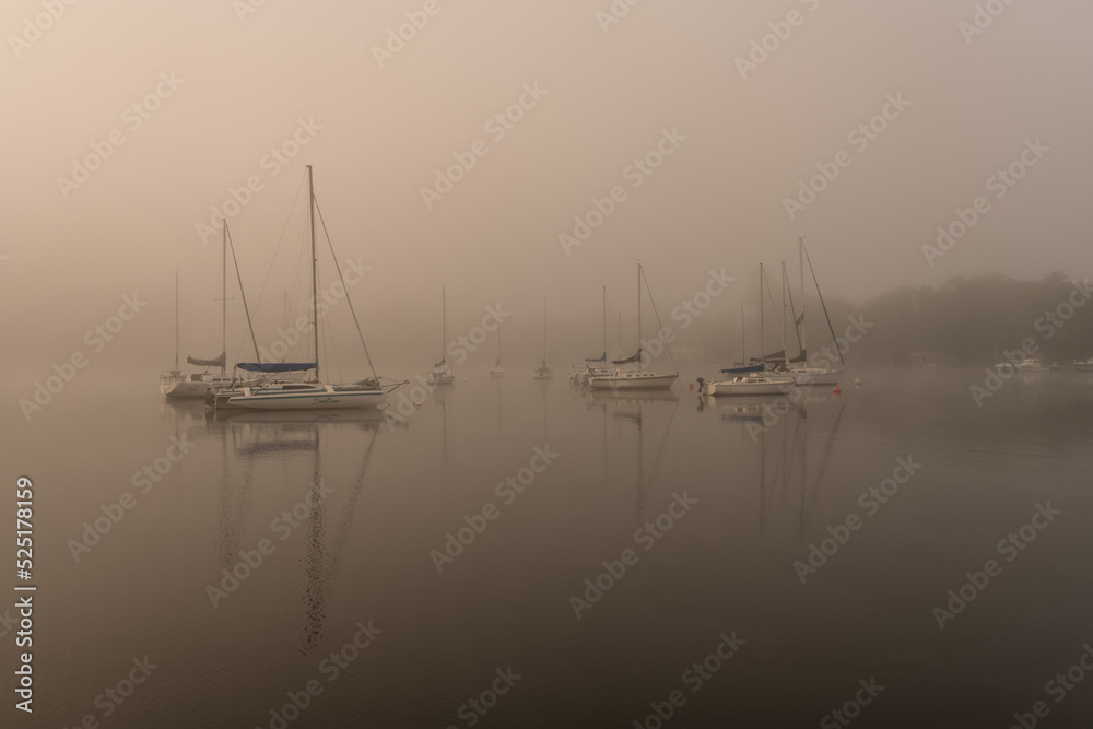 Boats in dawn mist on lake Boats in dawn mist on lake