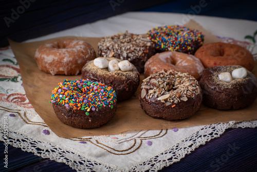 Beautiful doughnuts covered in chocolate glaze, sprinkles, marshmallows and chopped nuts
