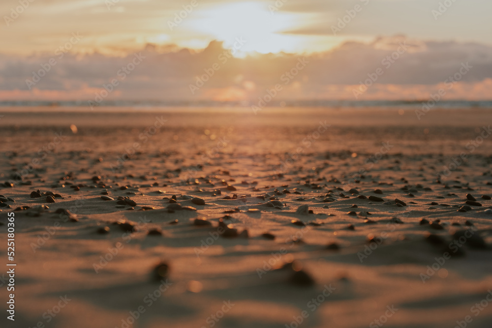 Blurred landscape with colorful sunset in beach of the Baltic sea. Picturesque sunset and sandy seashore with stones in the foreground. Spectacular sky in sunset. Blurred landscape with colorful sunset in beach of the Baltic sea. Picturesque sunset and sandy seashore with stones in the foreground. Spectacular sky in sunset.