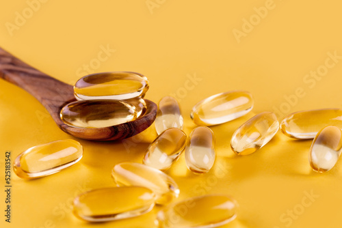 Omega 3 capsules lying on yellow background. Fish oil in pills. Health support and treatment. Biologically active additives. Selective focus.