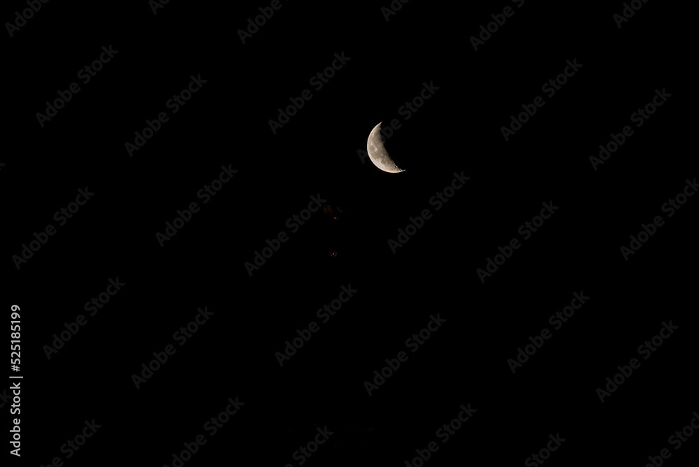 Beautiful orange quarter moon in the dark night sky over Riga city. Beautiful orange quarter moon in the dark night sky over Riga city.