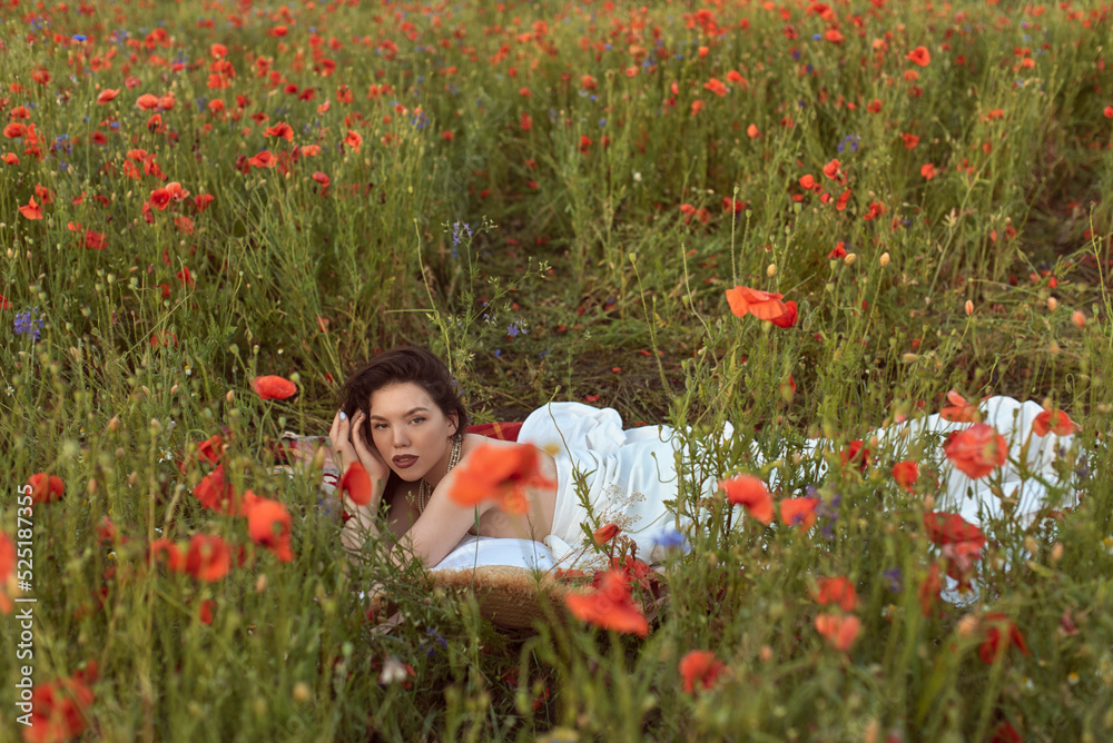 A young girl in a flowering poppy field A young girl in a flowering poppy field