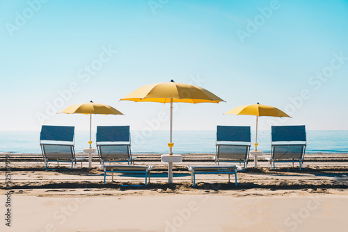 Fototapeta Naklejka Na Ścianę i Meble -  Idyllic beach with umbrella and sunbed at the Adriatic sea in Italy, Europe during summer.