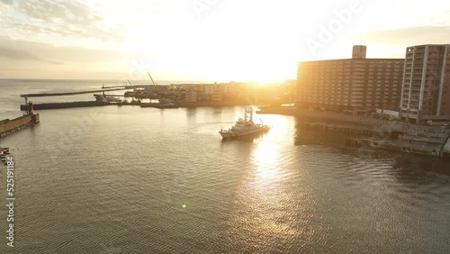 Patrol boat rotating in small harbor at sunset photo